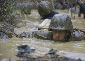 160112-N-YG415-115 OKINAWA, Japan (Jan. 12, 2016) Ensign Frank S. Sysko assigned to Naval Mobile Construction Battalion (NMCB) 3 holds his breath while he exits a mud-filled trench during a jungle warfare training evolution hosted by Marines with the Jungle Warfare Training Center (JWTC). The JWTC endurance course tests the Seabees will, stamina and the ability to work together as a team. NMCB 3 is deployed to several countries in the Pacific area of Operations conducting construction operations and humanitarian assistance projects. (U.S. Navy photo by Mass Communication Specialist 1st Class Michael Gomez/Released)