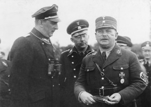 Der große SS-Schutz-Staffel-Appell der Gruppe Ost der SS. in Berlin! Der Stabschef Hauptmann [Ernst] Röhm, (rechts) der Reichsführer der SS. [Heinrich] Himmler, (mitte) und der Gruppenführer der Gruppe Ost der SS. [Kurt] Daluege, (links) beim Gespräch im Lager in Döberitz. August 1933 (Ausschnitt)